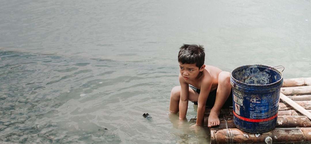 Boy washing in polluted water